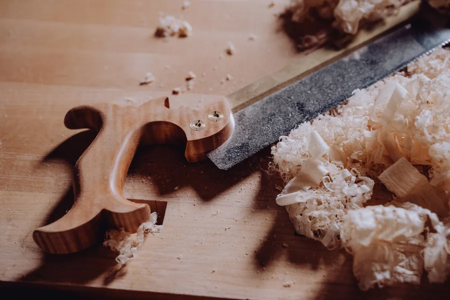 Couteau de coupe et copeaux de bois clairs sur un établi d'atelier